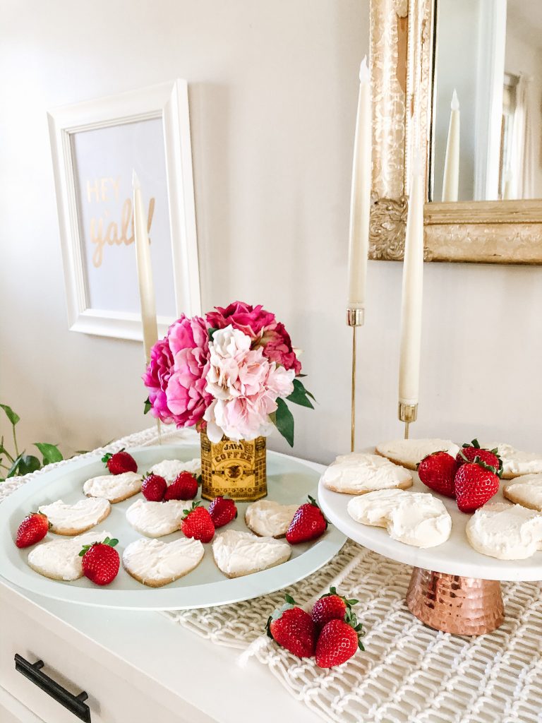 sugar cookies on a tray and cake stand with candles beside them