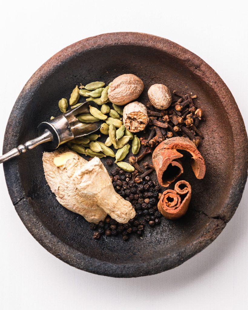 whole chai tea spices in a black bowl