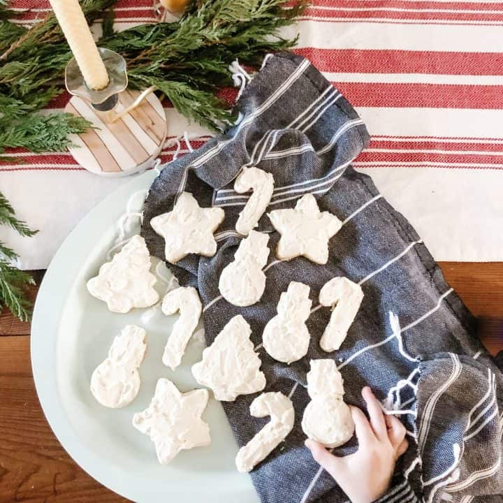 Freshly baked sugar cookies with buttercream icing sit atop a serving platter, waiting to be enjoyed.