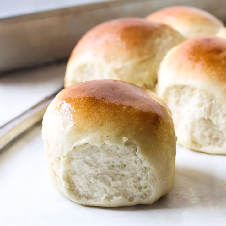 Close up of baked yeast rolls on a white counter