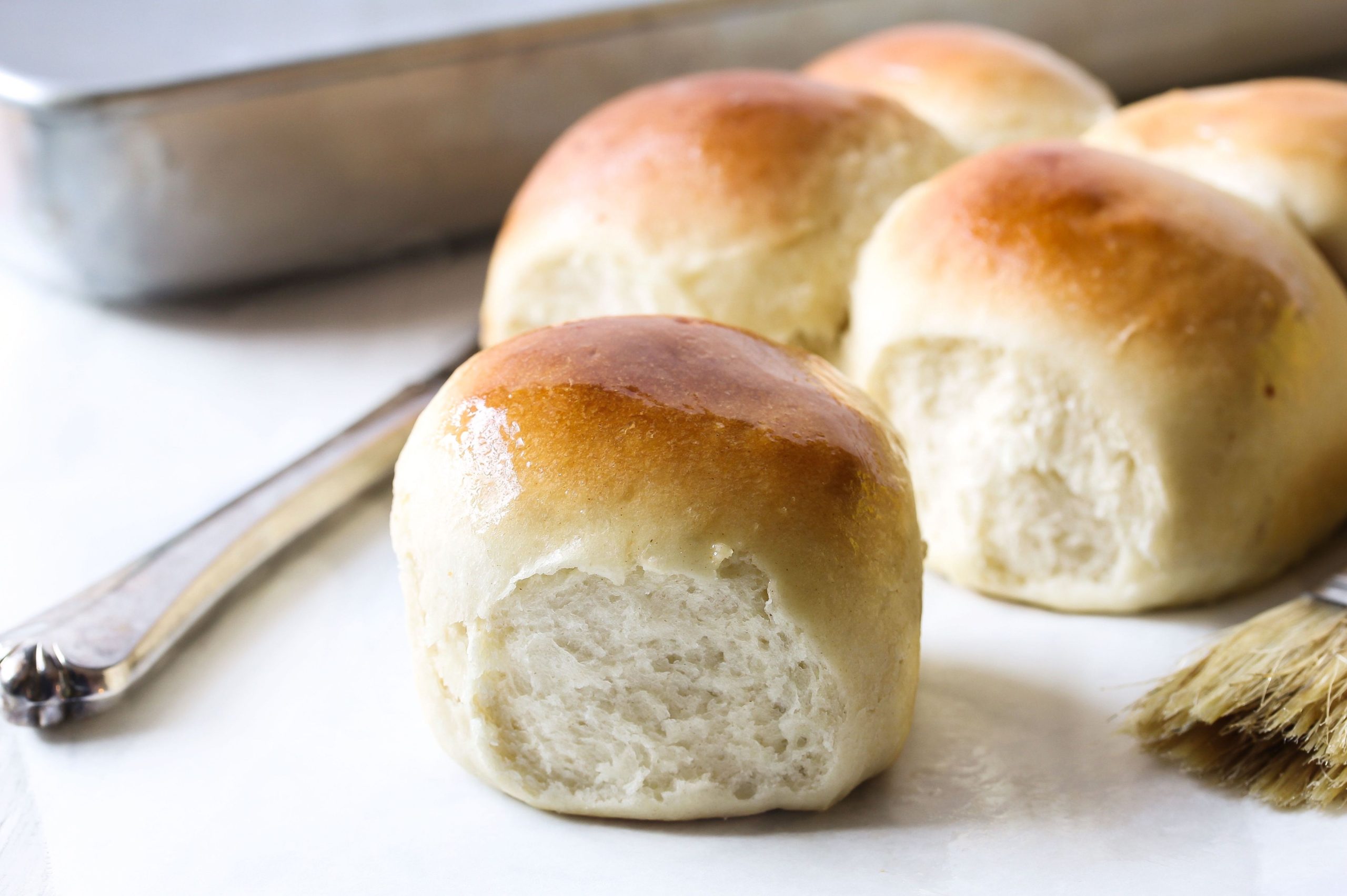 Close up of baked yeast rolls on a white counter