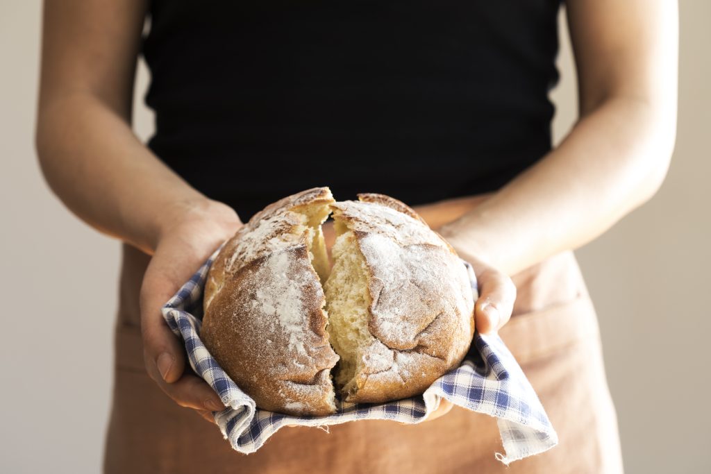 Woman holding a baked loaf of overnight bread