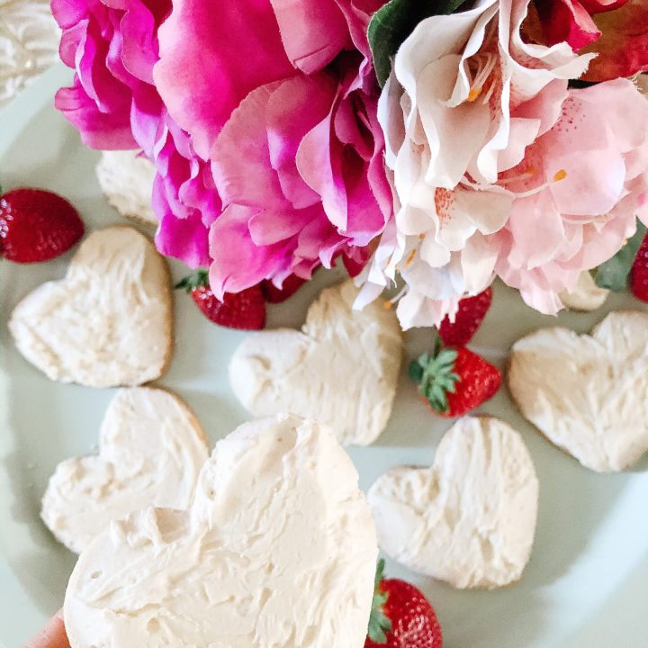 close up of heart-shaped sugar cookie with white icing