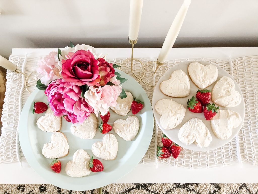 close up of sugar cookies on a teal tray and cake stand with strawberries