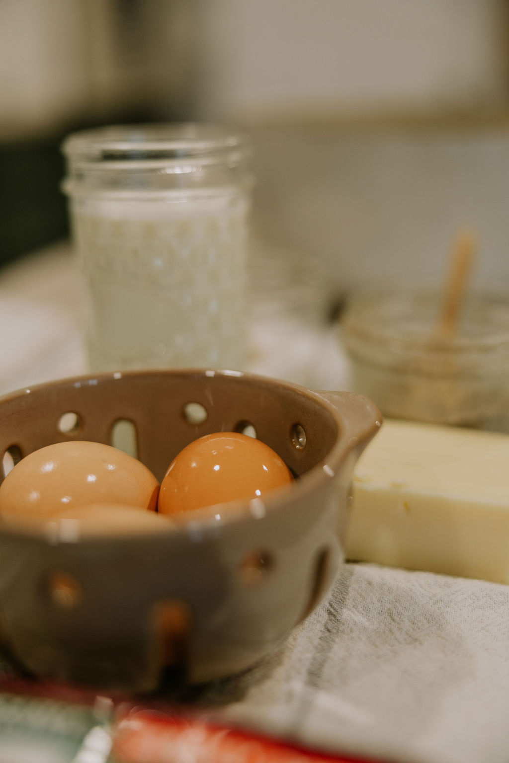 Ingredients like fresh eggs and butter sit gathered, ready to add to the recipe.