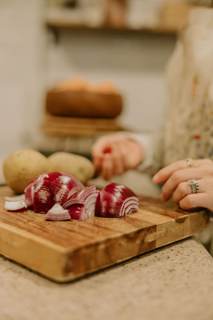 A chopped red onion sits on a wooden cutting board.