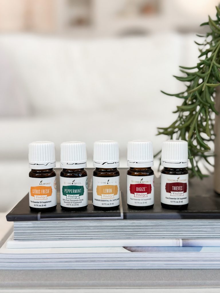 5 essential oil bottles sitting on a book