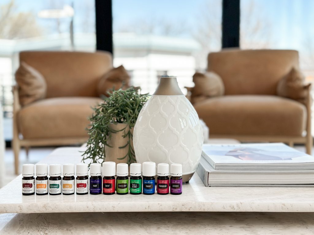 12 essential oil bottles and a white diffuser on a table