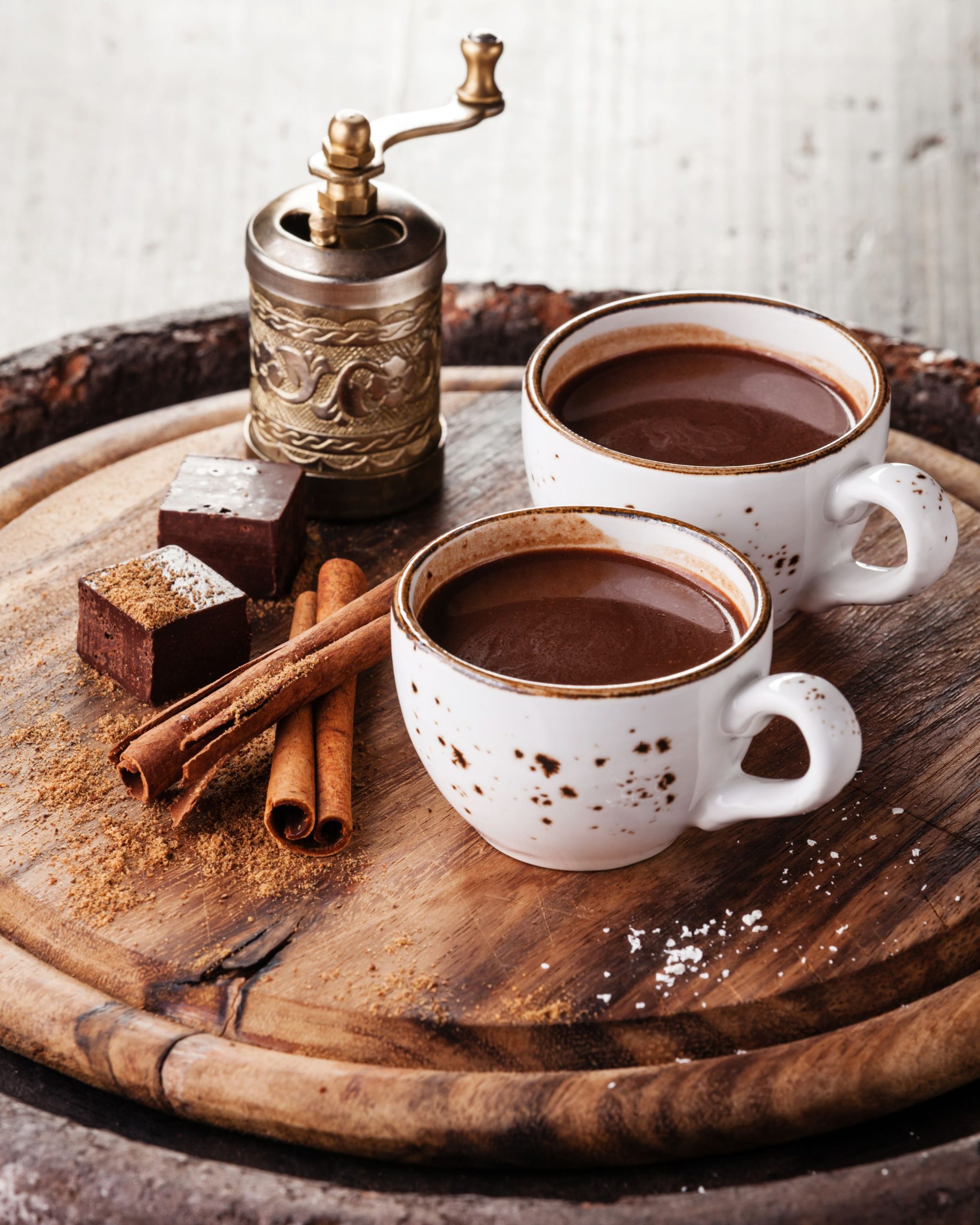 two cups of hot cocoa on a wooden tray