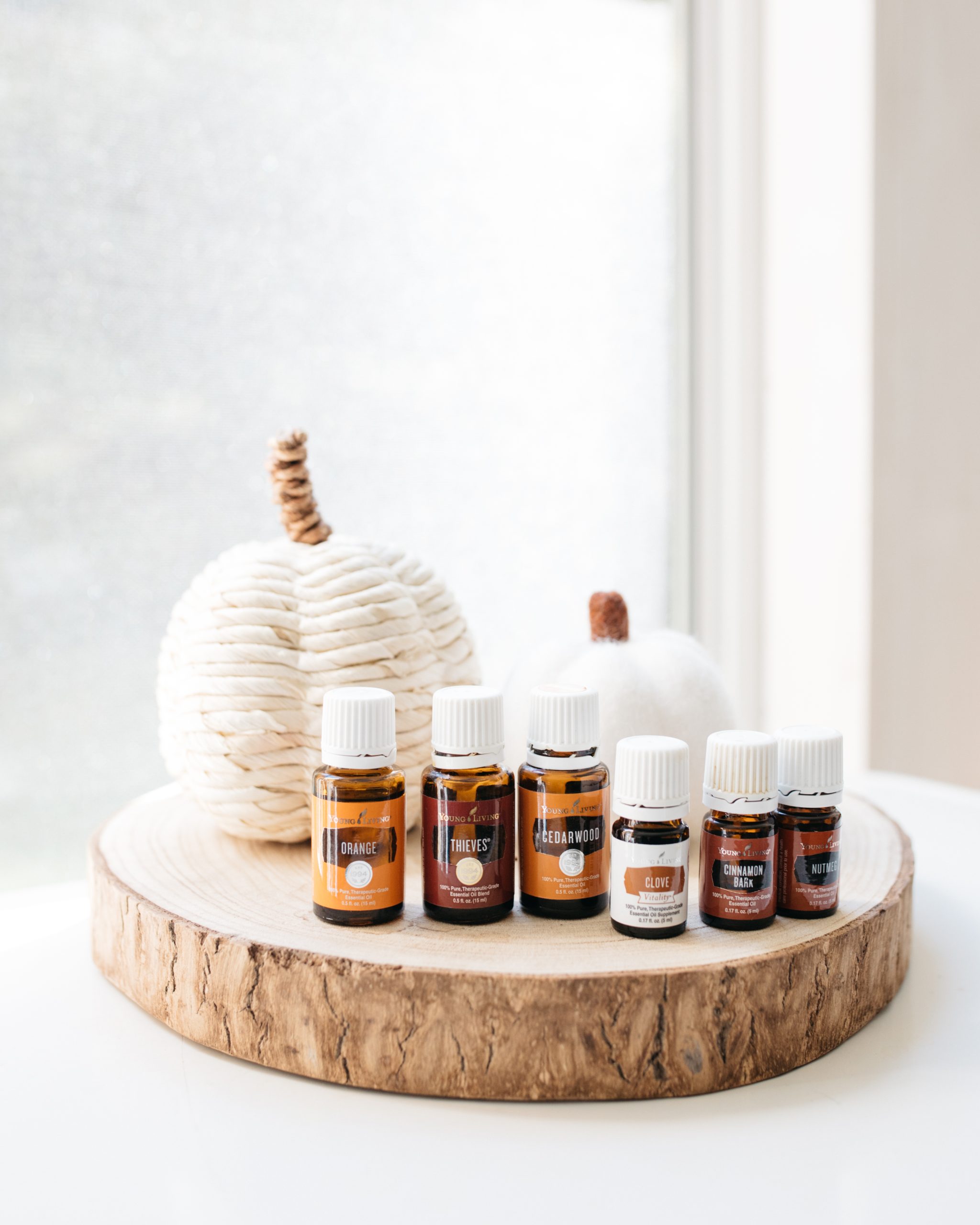 essential oil bottles on a wooden plate with pumpkins