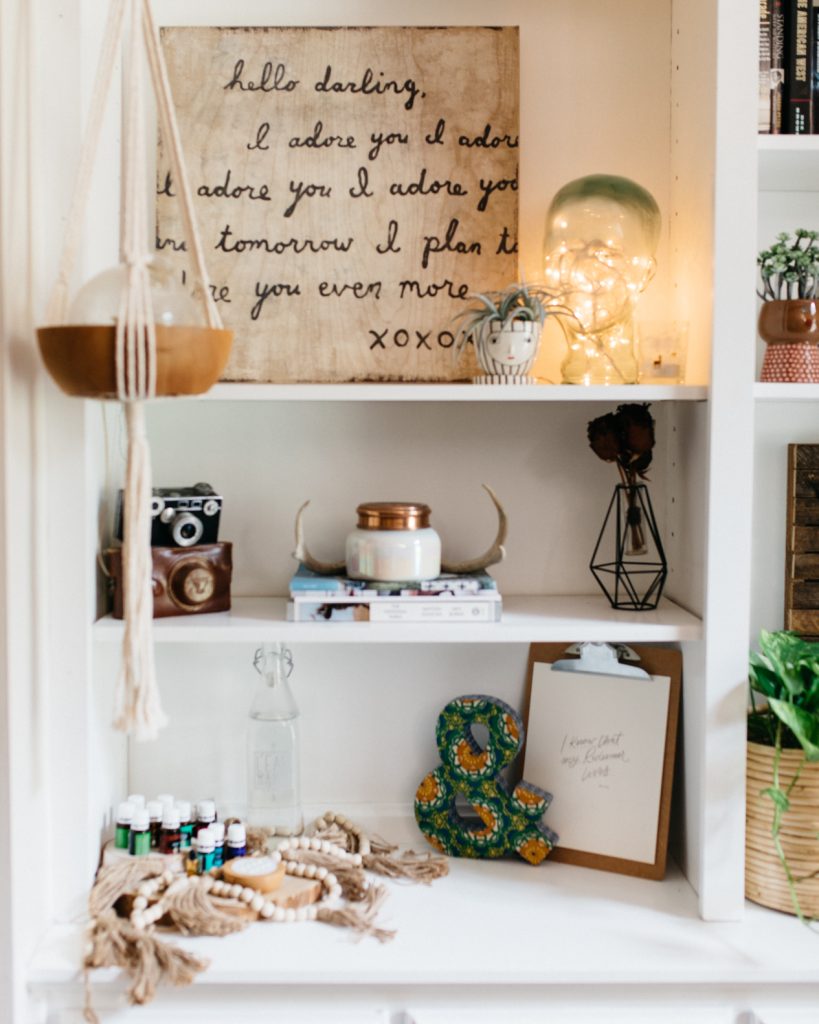 bookshelf with diffuser, candles, and decor