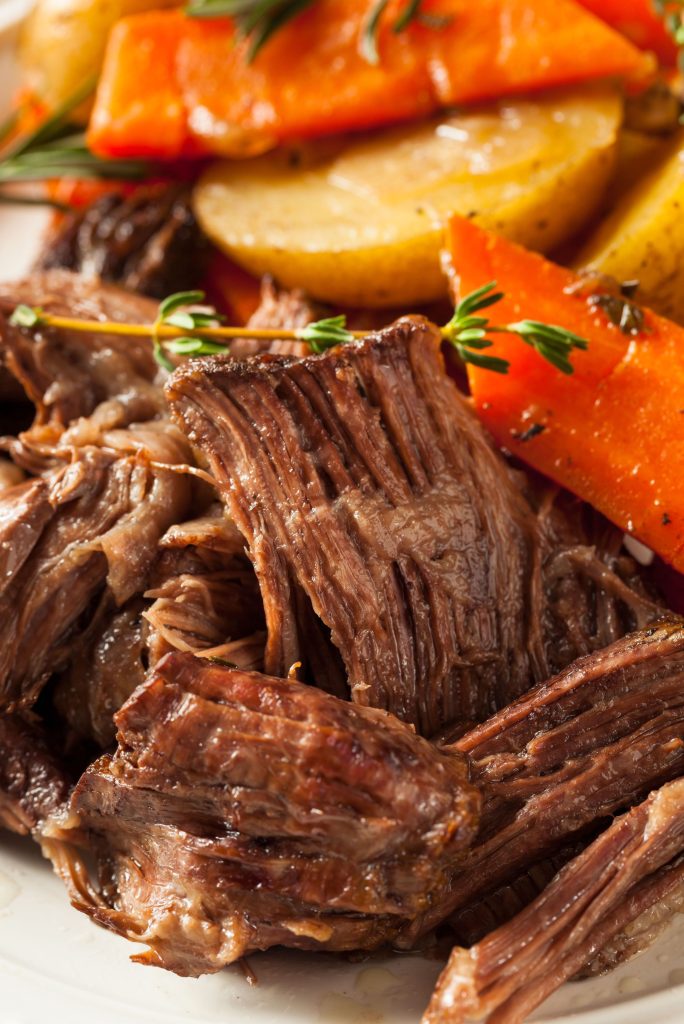 Close up of cooked roast and carrots and potatoes