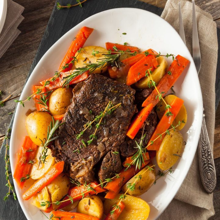 cooked roast and root vegetables on a white platter