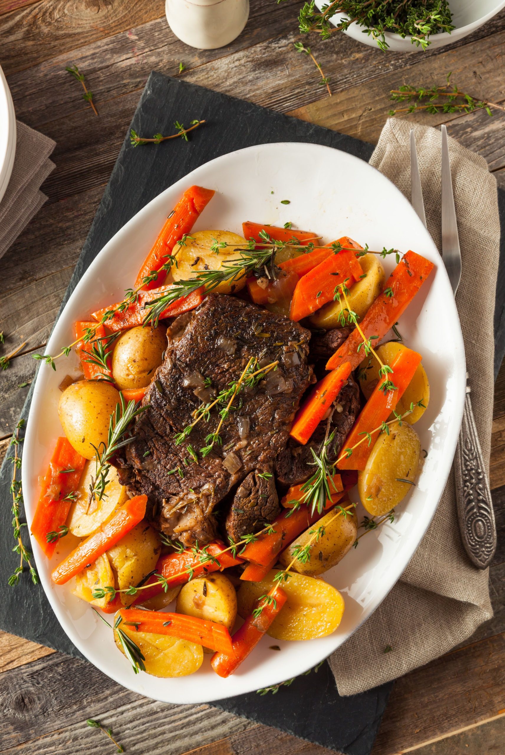 cooked roast and root vegetables on a white platter