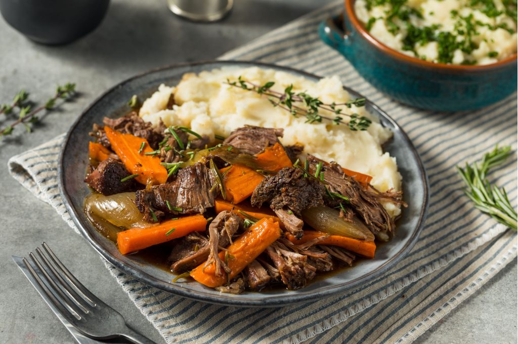 plate with roast, carrots, and rice on a striped napkin