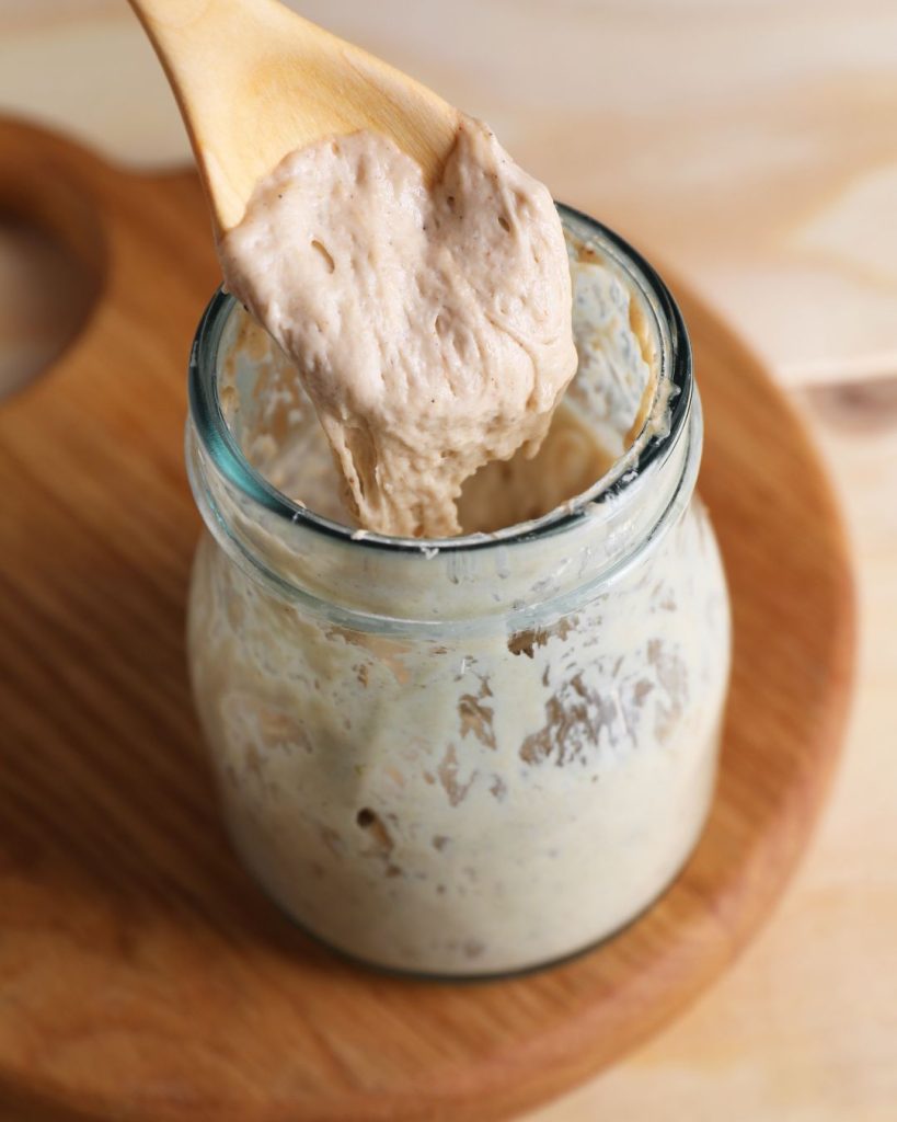 close up of stiff dry sourdough starter in a glass jar