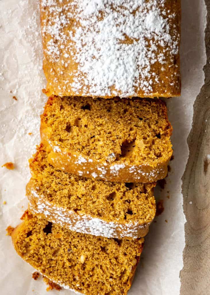 close up of sliced pumpkin bread with powdered sugar on top