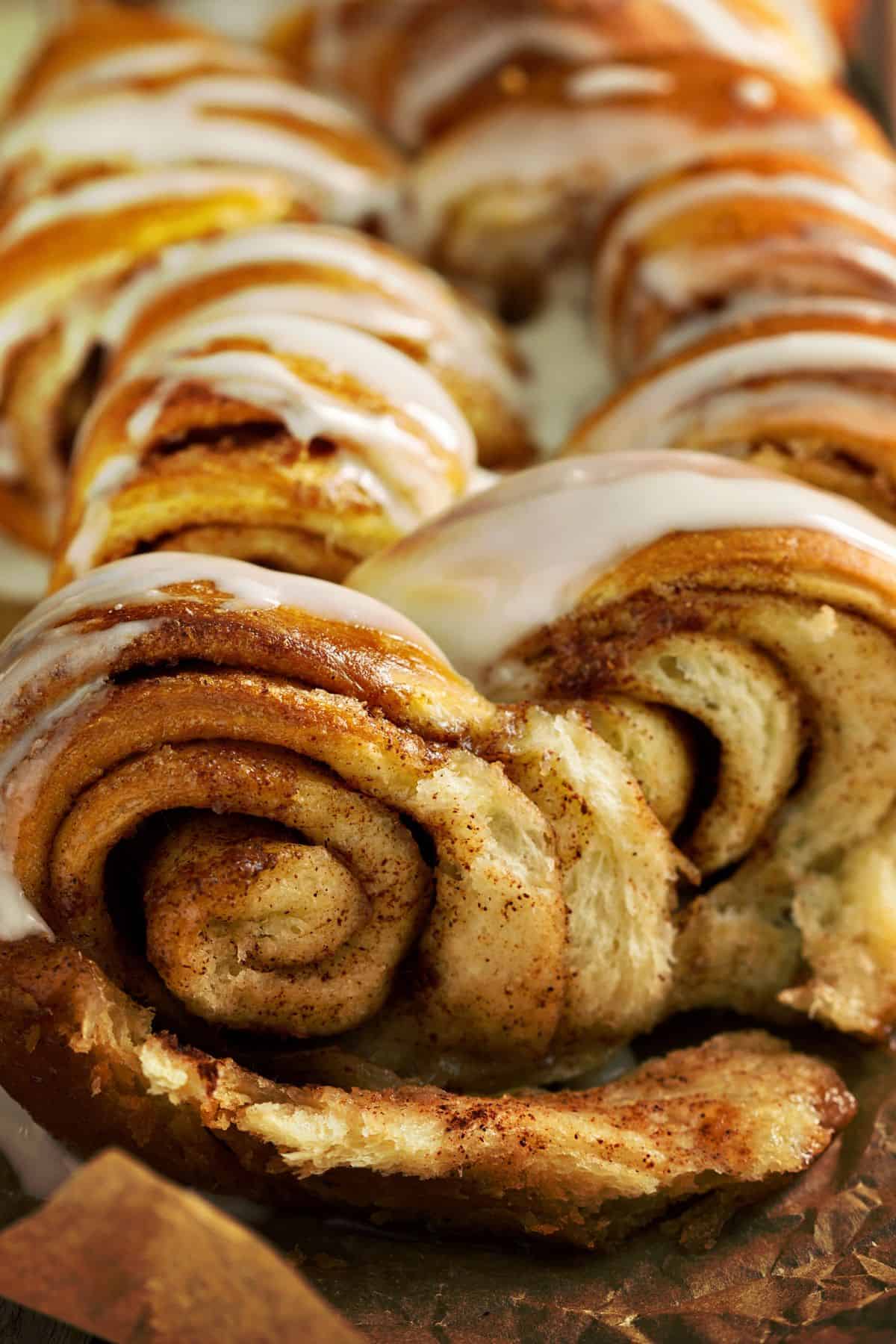 Close up of an iced loaf of cinnamon pull-apart bread, warm and fresh from the oven.