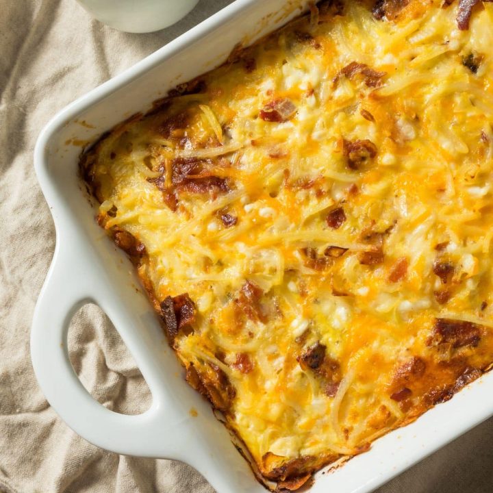 Close up of a cheesy, protein-rich breakfast casserole in a white baking dish