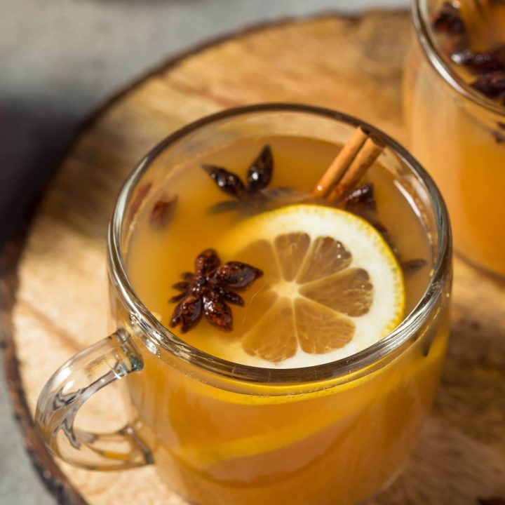 close up of wassail in a glass mug with an orange slice, star anise, and a cinnamon stick -- so warm and cozy!