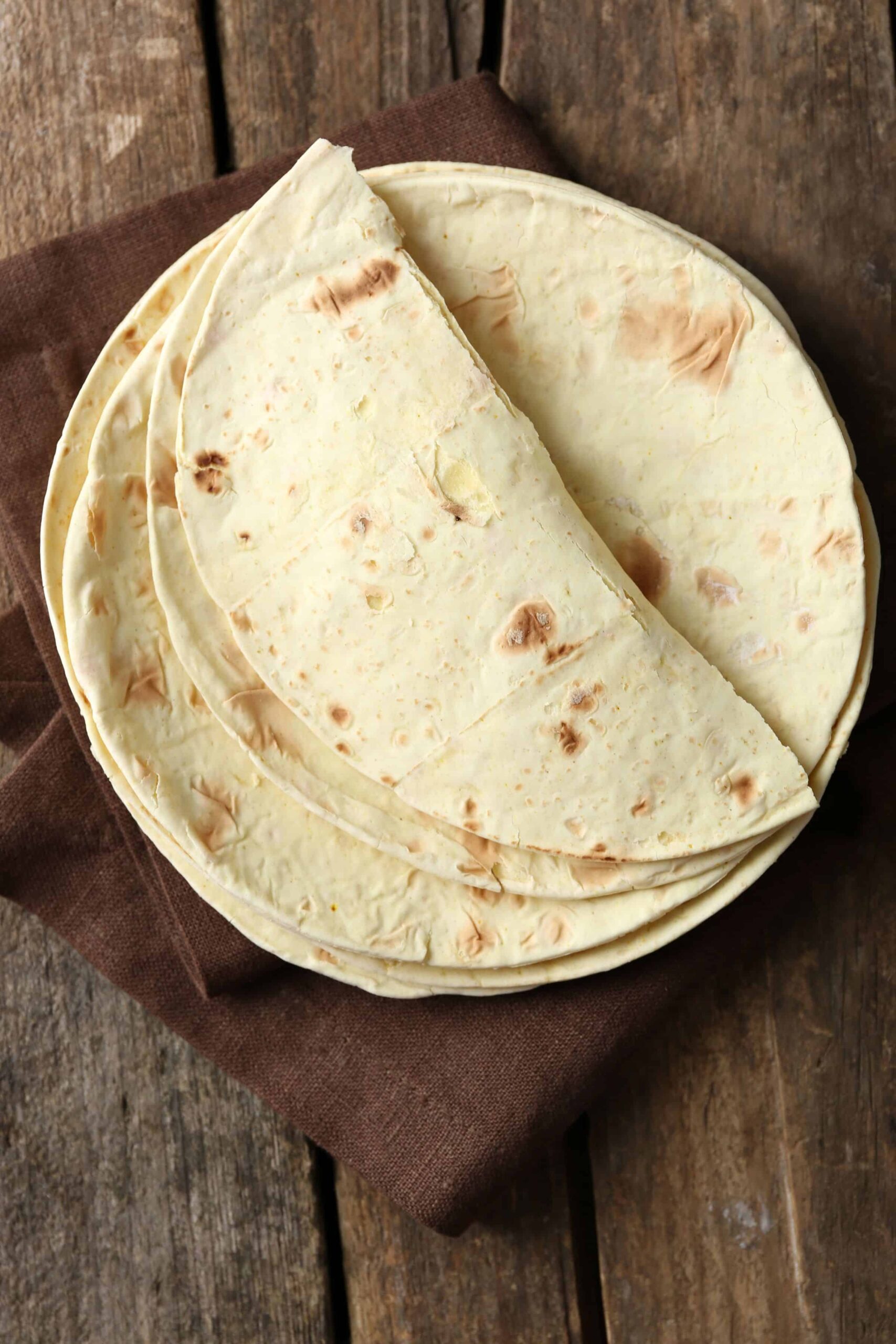 Whole grain tortillas on a wooden cutting board
