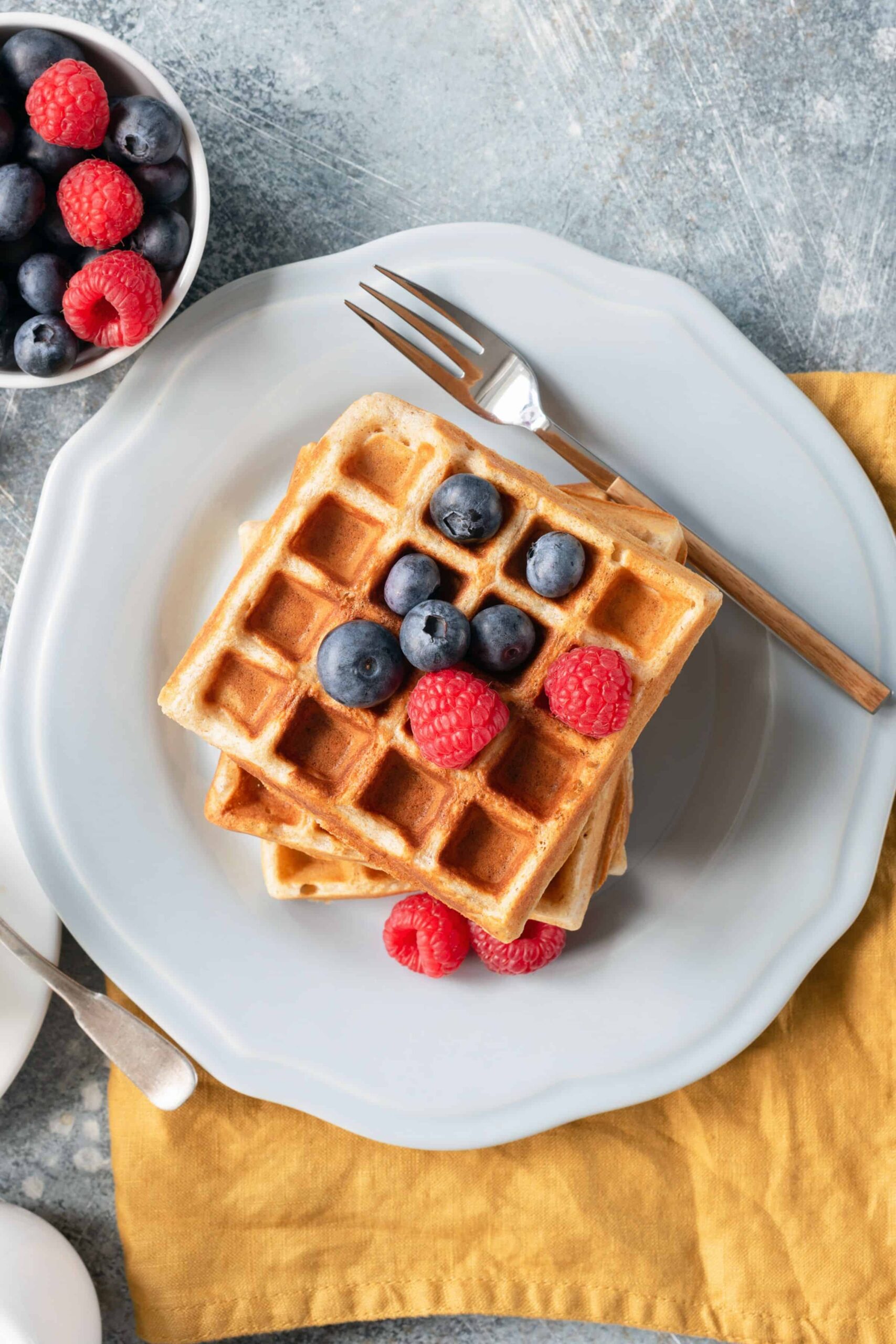 Close up of whole wheat waffles with fresh berries ready to eat.