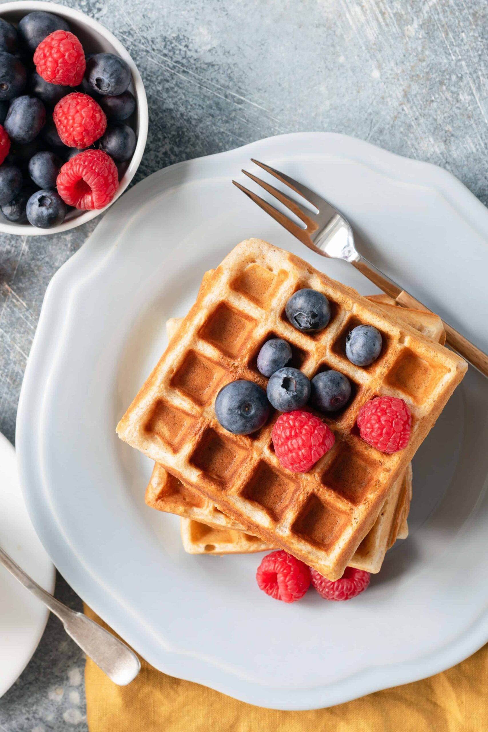 fresh milled whole wheat waffle stack with blueberries and raspberries