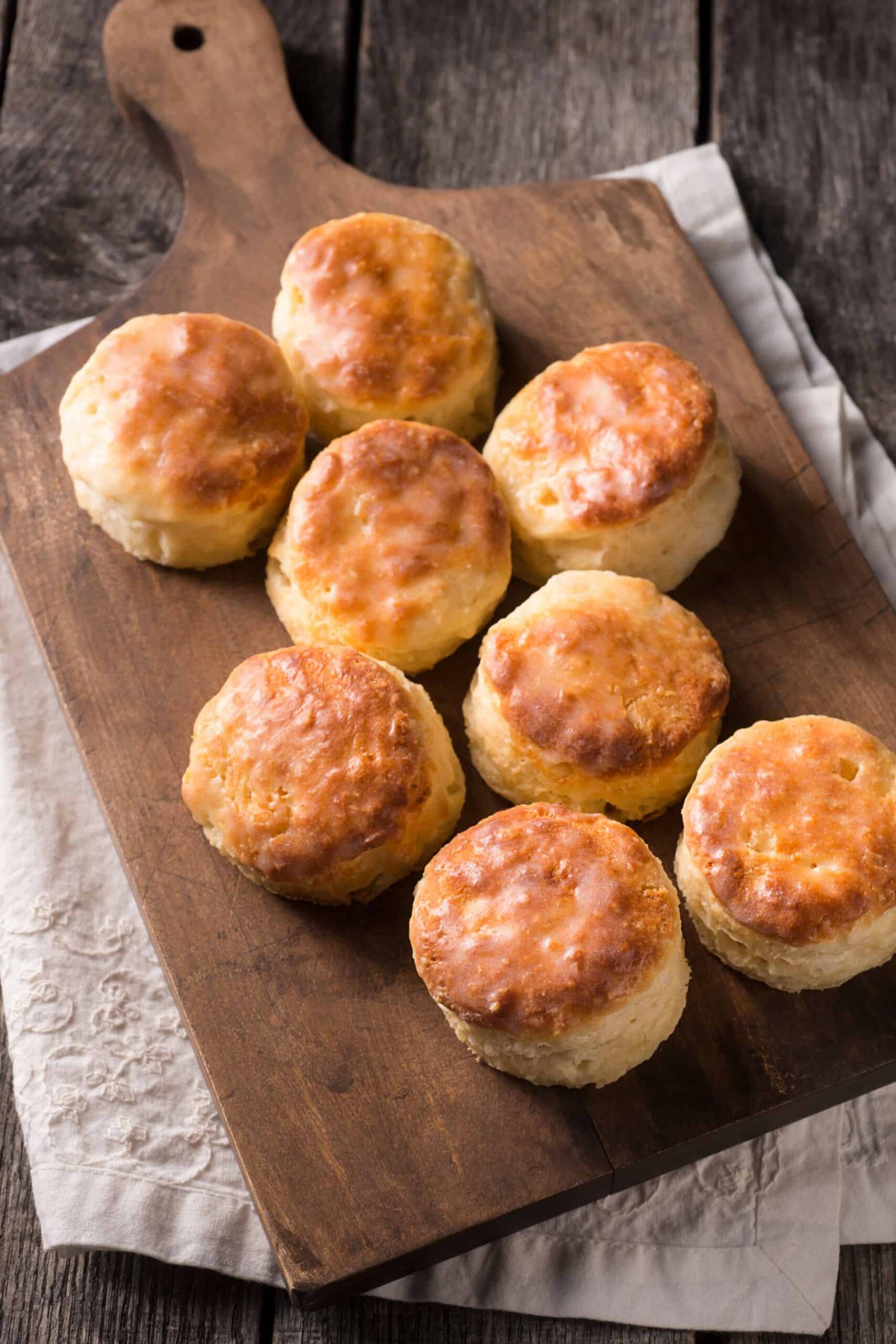Freshly baked biscuits on a wooden cutting board