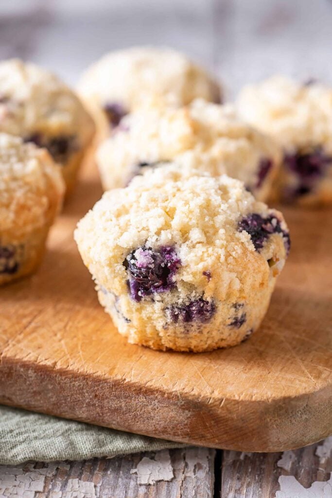 Whole wheat blueberry muffins with crumble topping on a cutting board