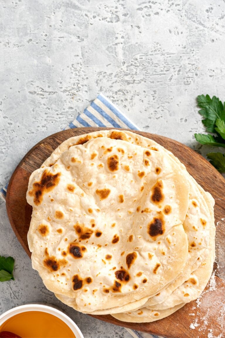 Fresh sourdough flatbread on a wooden cutting board.