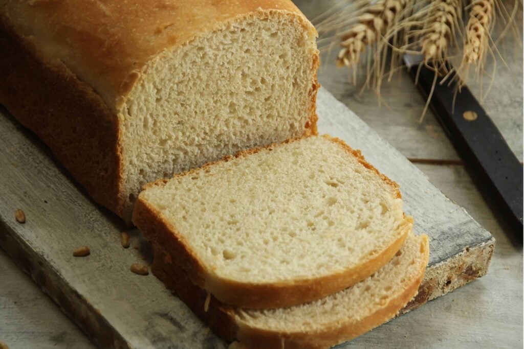 Sliced loaf of freshly made bread on a wooden cutting board.