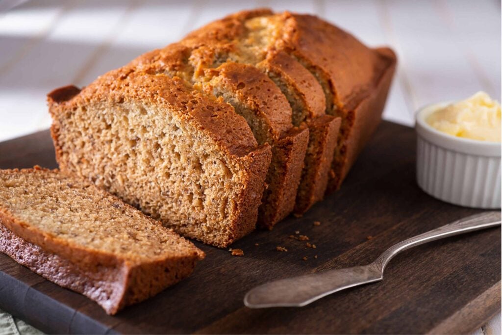 kodiak cakes banana bread on a cutting board with butter