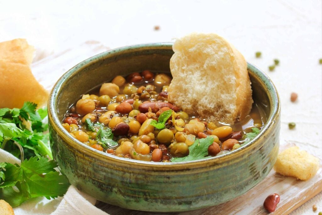 Homemade 7 bean soup recipe with fresh crusty bread and herbs