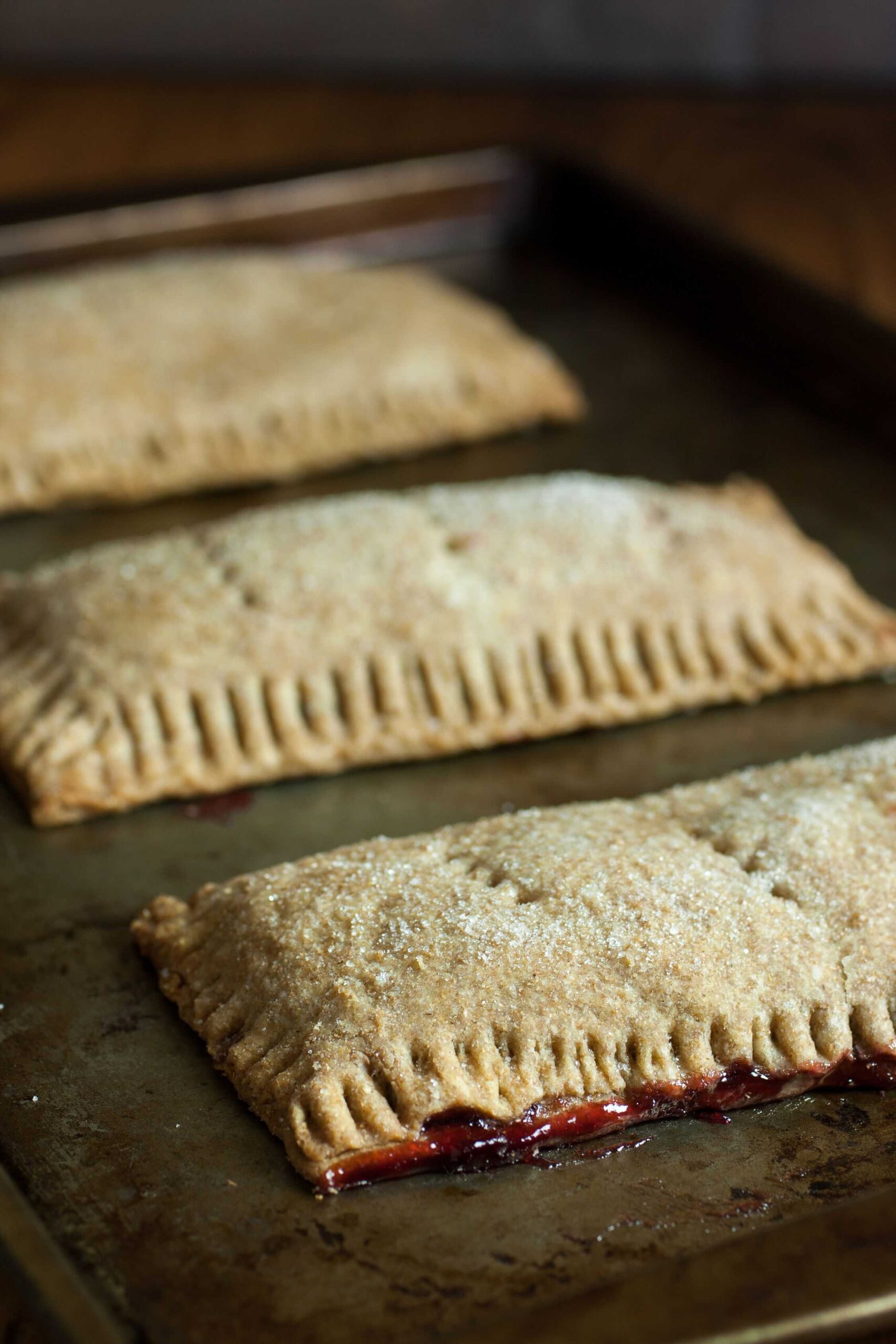 Homemade pop tarts cooling on a baking sheet
