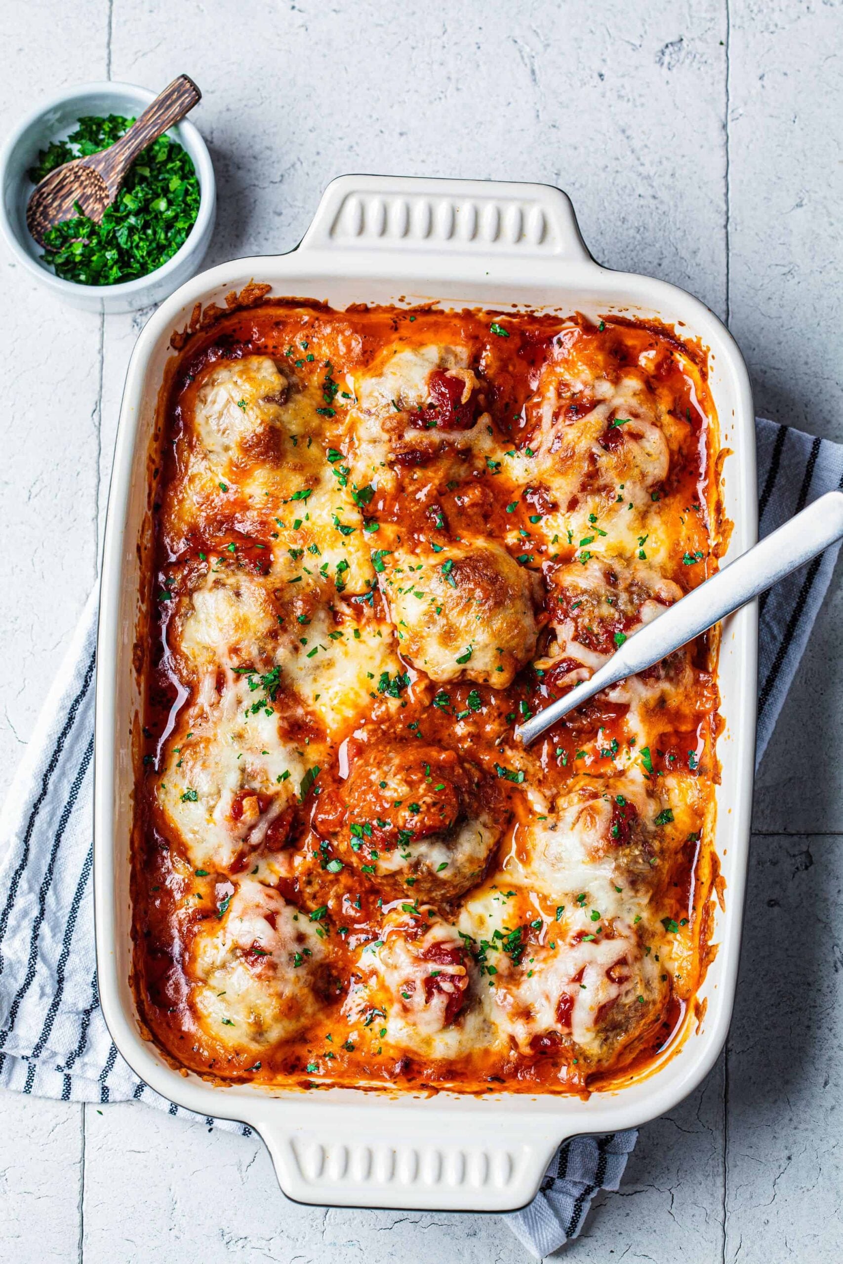 Warm metaball casserole topped with melted cheese and fresh herbs.