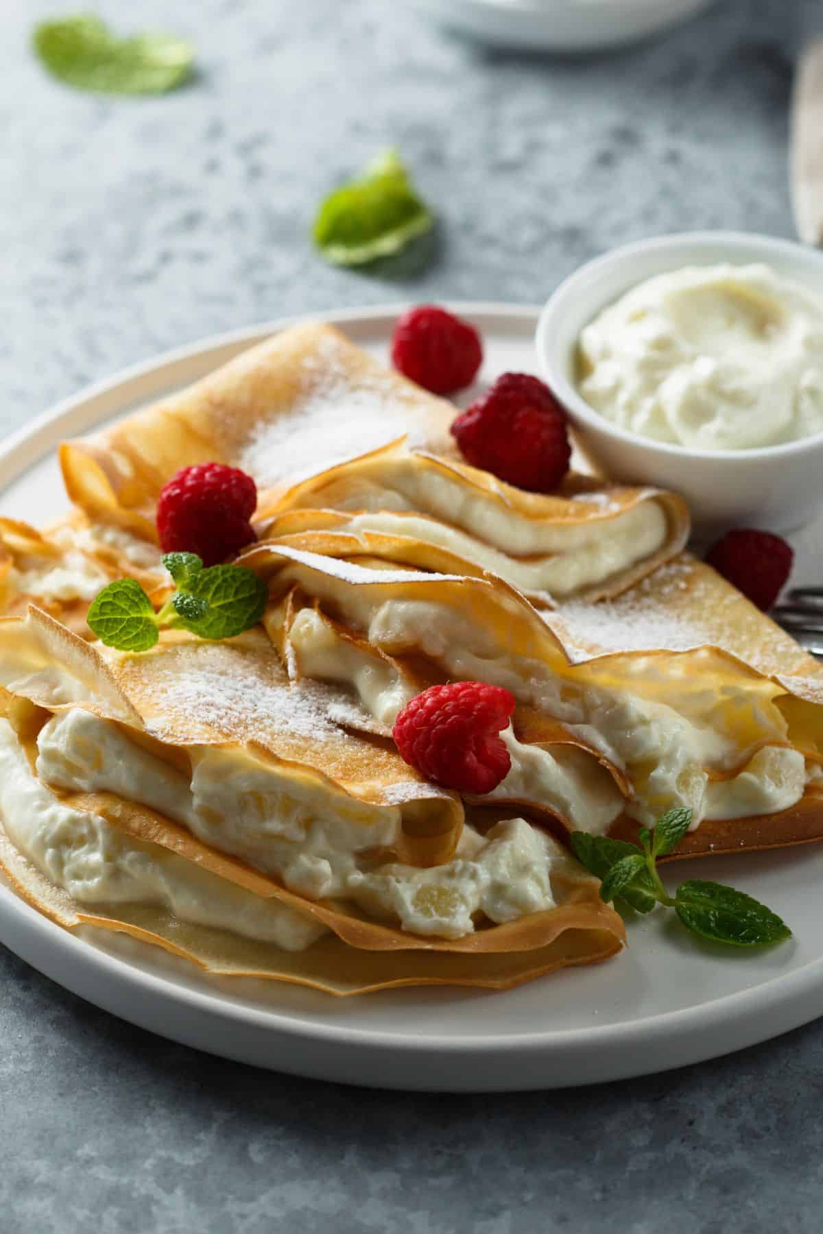 A homemade sourdough crepe recipe with raspberry filling and whipped cream