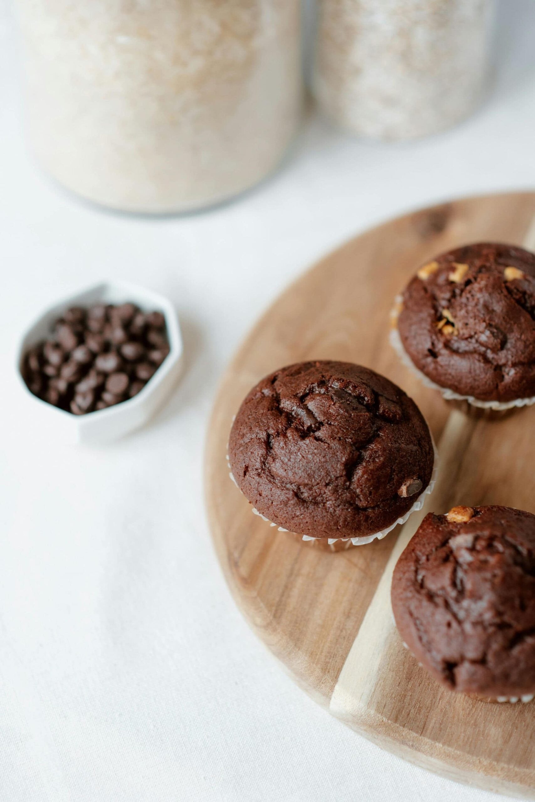 Chocolate banana muffins made with fresh milled flour on a cutting board with wheat in the background