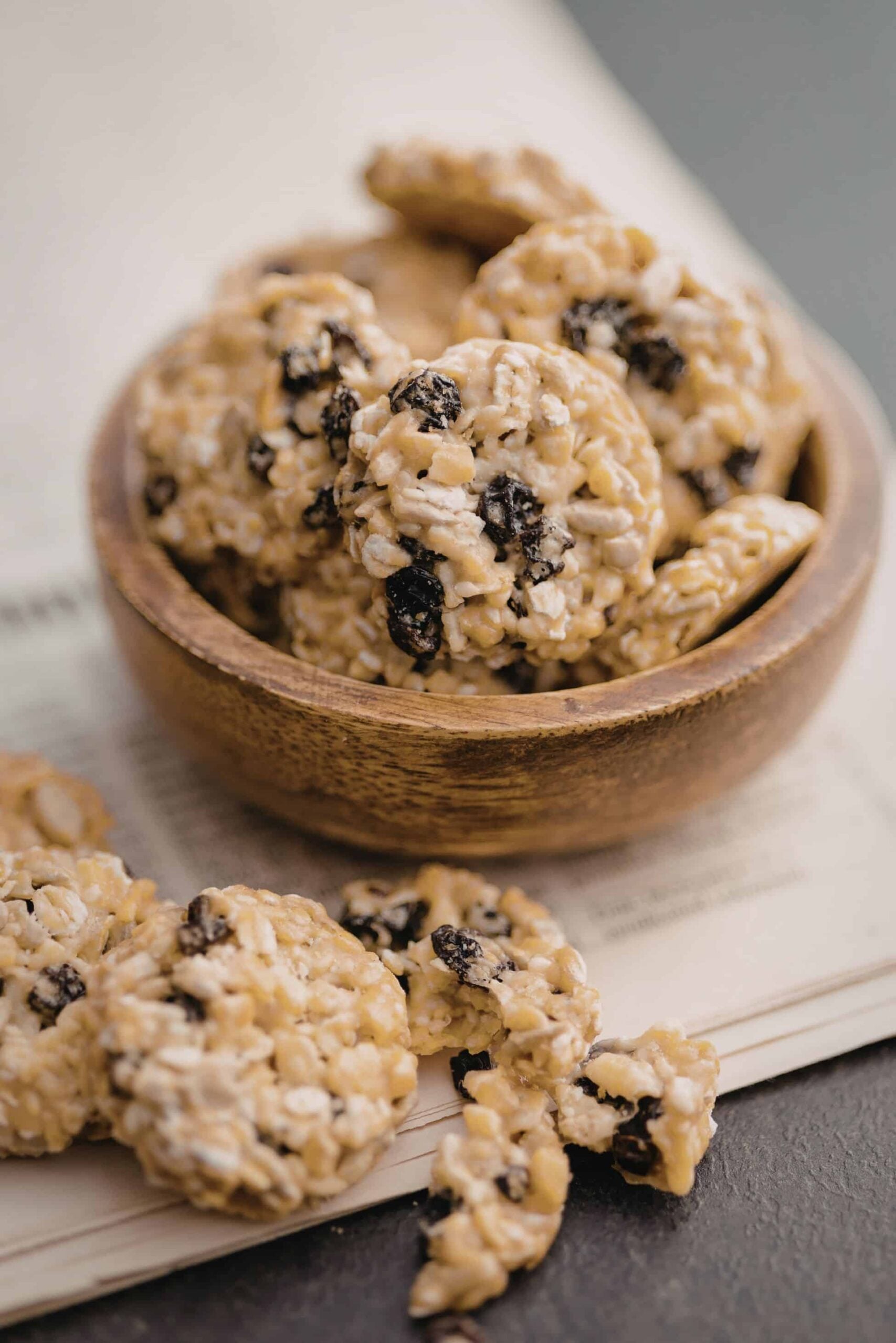 oatmeal raisin cookies in a wooden bowl sitting on newspaper
