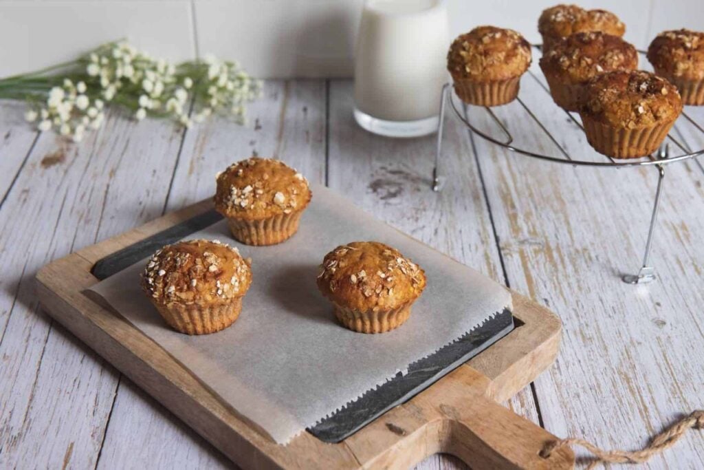Morning glory muffins on a tray and cake stand with flowers and milk