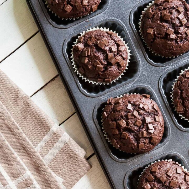 Freshly baked whole wheat chocolate zucchini muffins in a muffin tin