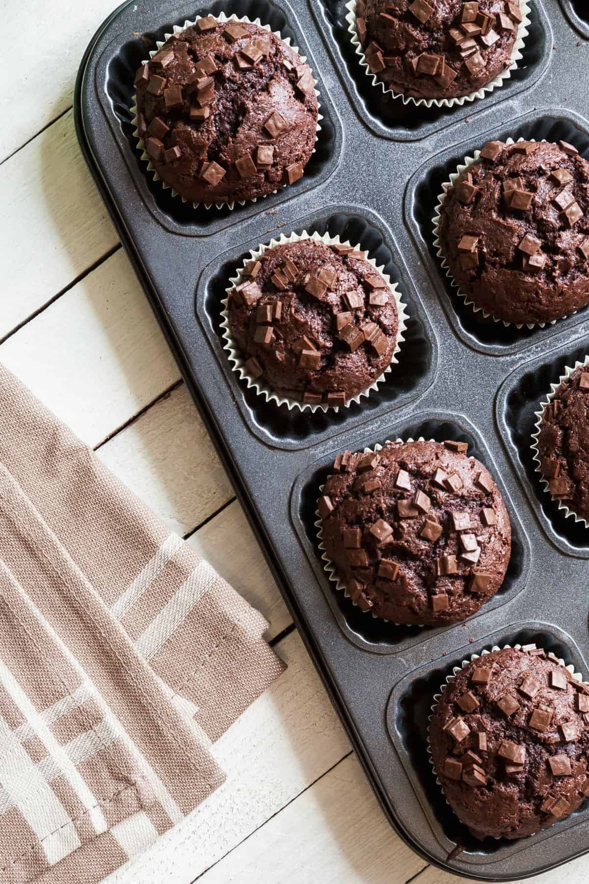 Freshly baked whole wheat chocolate zucchini muffins in a muffin tin