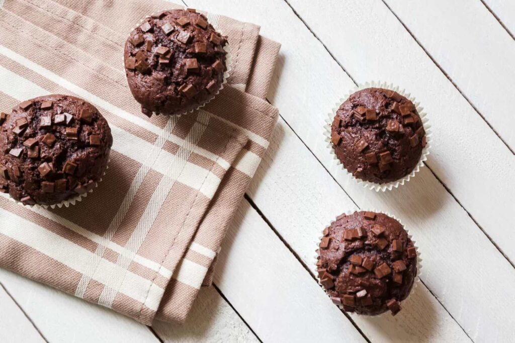 Whole wheat chocolate muffins on a tea towel