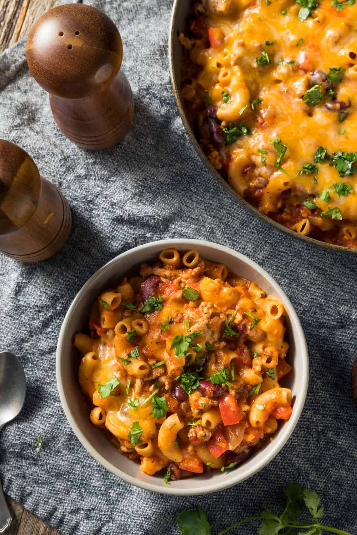 Cheesy turkey chili mac in a while bowl with a spoon